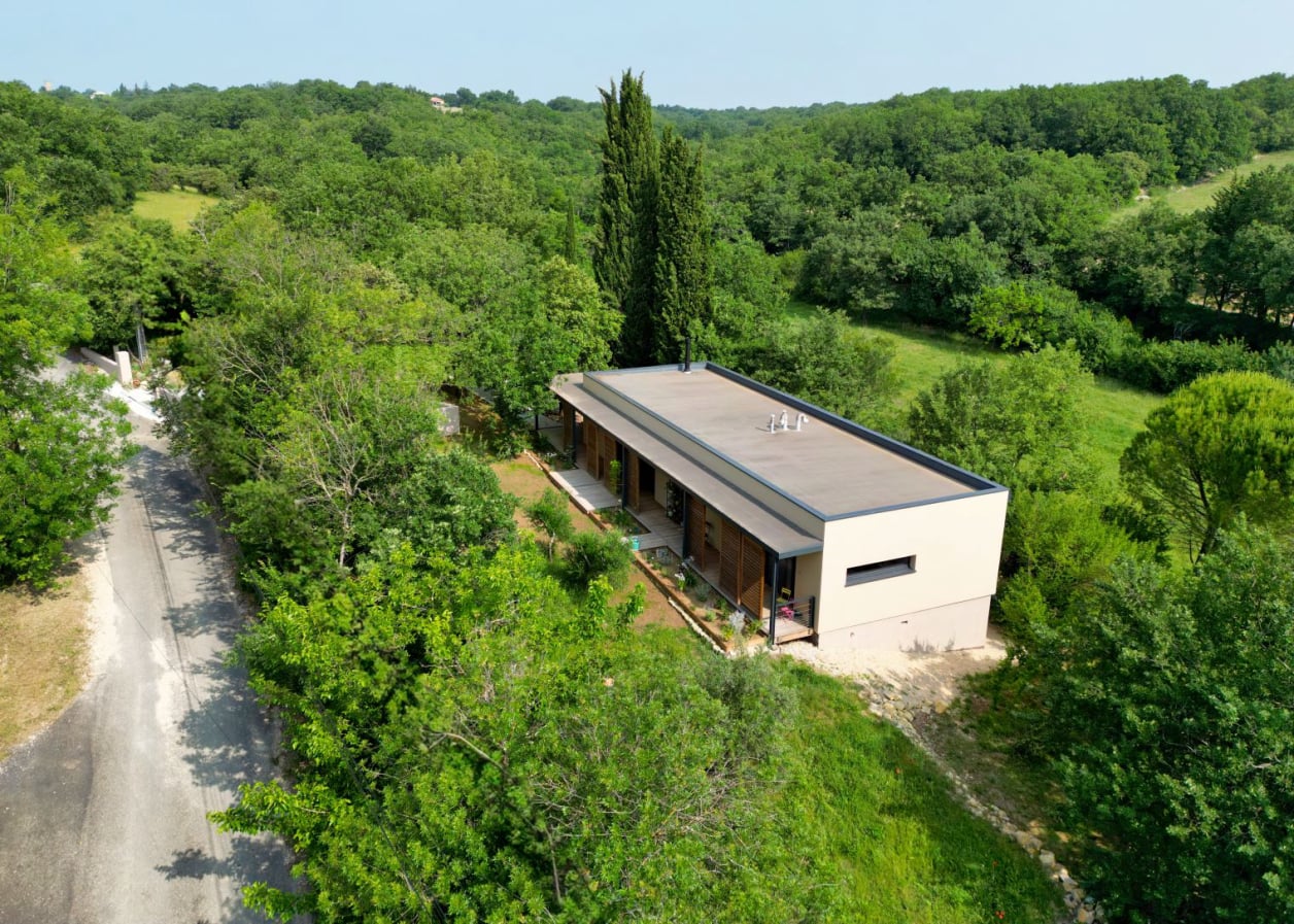 Maison familiale à ossature bois conçue par l'architecte Benoît Gilet sur un terrain en pente.